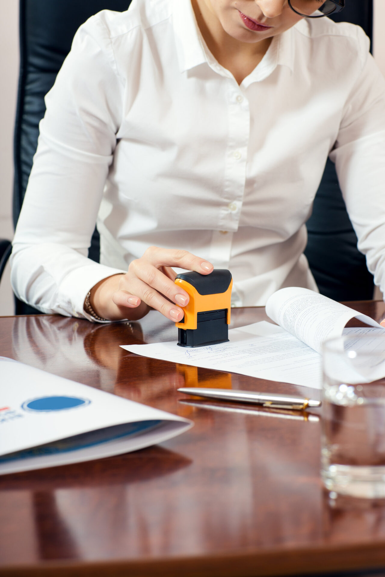 businesswoman stamping document, working at her office