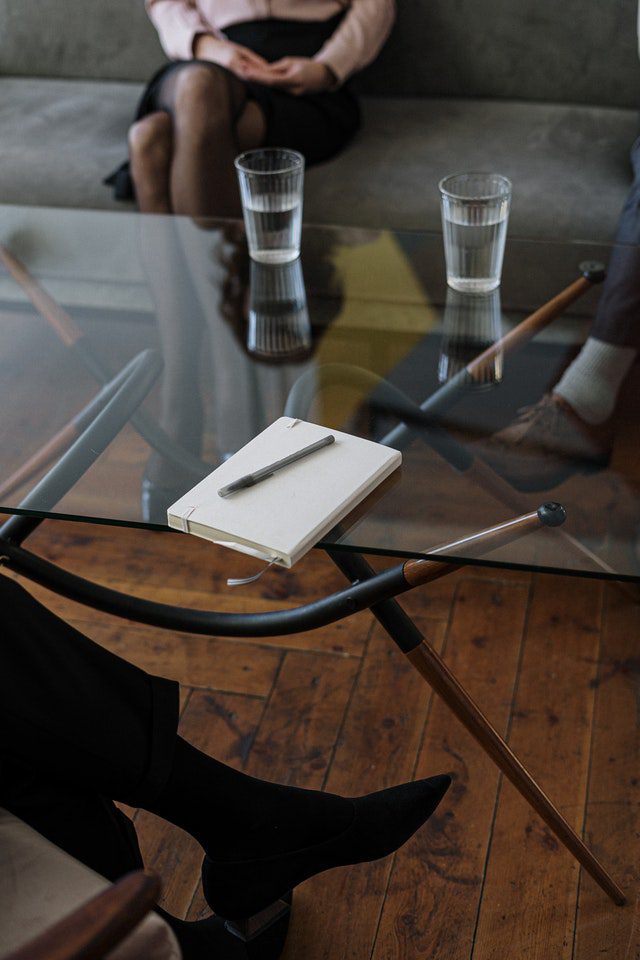 Woman in Black Long Sleeve Shirt Sitting on Brown Wooden Chair